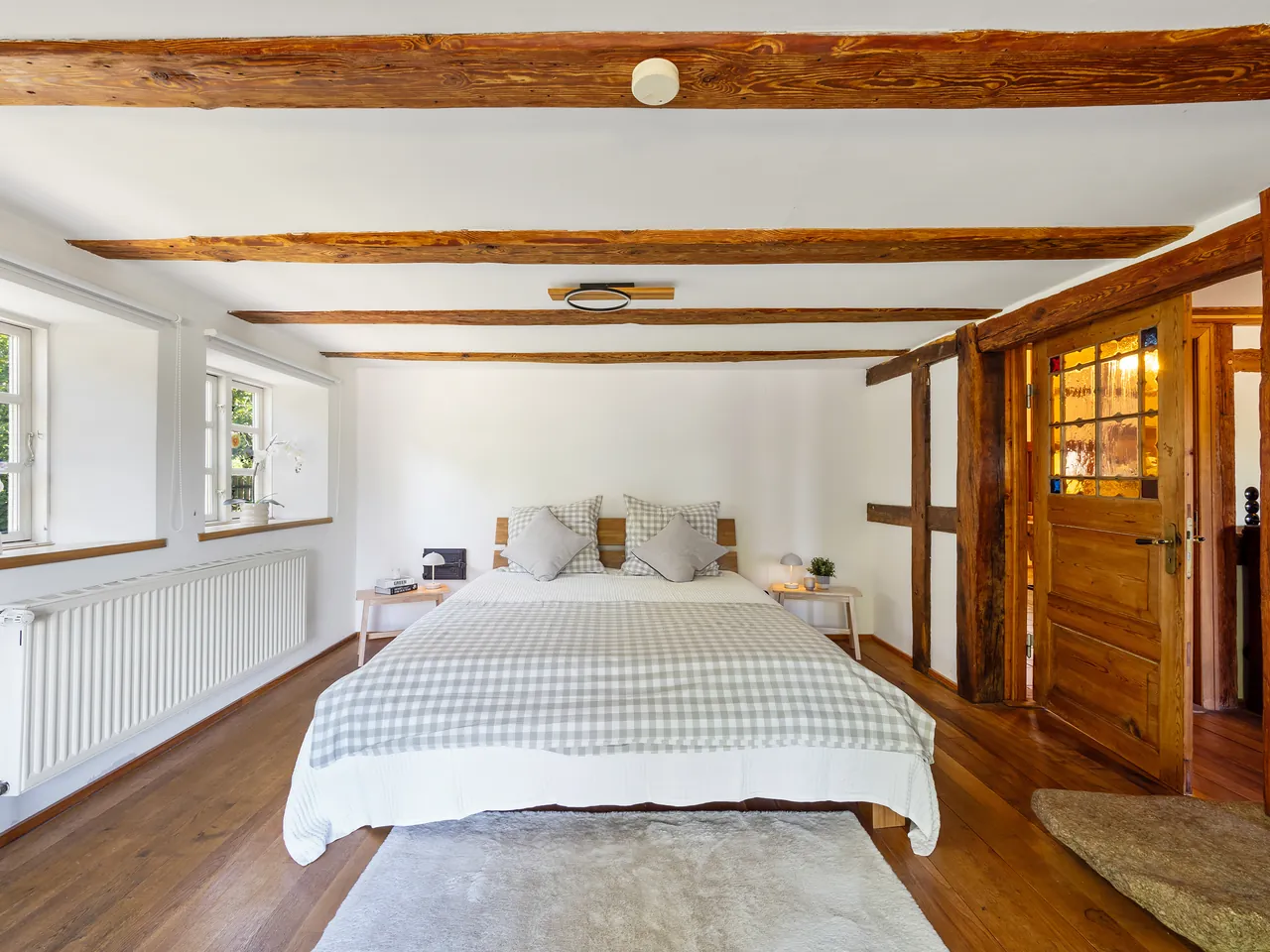 Schlafzimmer mit sichtbarer Holzbalkendecke in einem Reetdachhaus