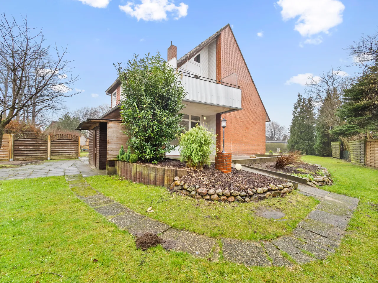 Einfamilienhaus mit Balkon, Garten und geschwungenem Plattenweg
